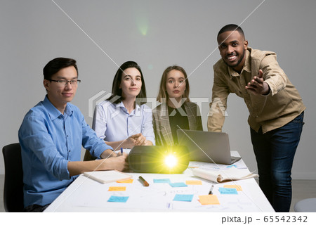 Young black man pointing at you while making presentation to group of colleagues 65542342