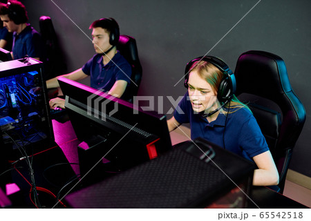 Pretty long-haired girl in headset talking to someone in front of computer 65542518