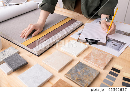 Hands of female interior designer with pencil over paper making notes Hands of female interior designer with pencil over paper making notes 65542637