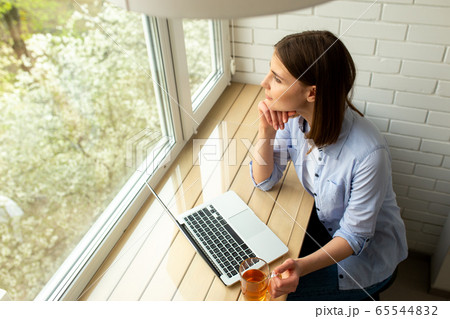 Young woman looking at window at home 65544832