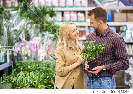 good-looking couple looking for flowers in pots 65544848