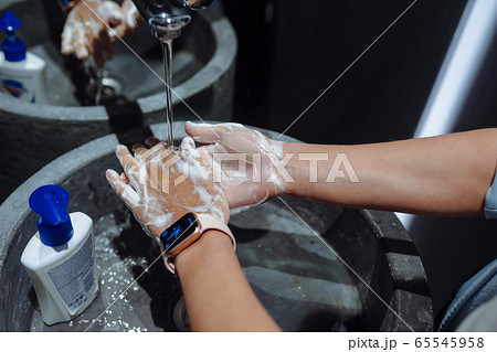 Woman washing hands to protect against the coronavirus 65545958
