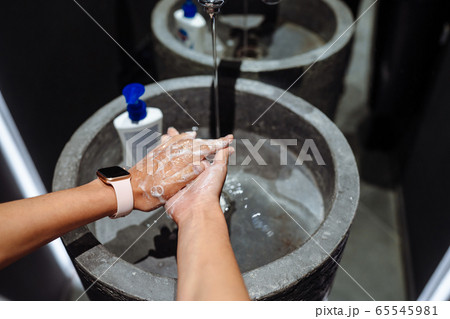 Woman washing hands to protect against the coronavirus 65545981