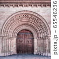 Facade with door in an arched opening, which is decorated with patterns and ornaments 65546236