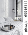 White bedroom interior with a wine glass on a tray on the bed 65546342