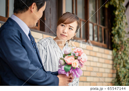 男性から花束をもらって困るアジア人女性 65547144