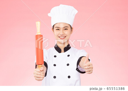Beautiful Asian chef woman smile and holding rolling pin isolated on pink background,Happiness and Cheerful Professional chef Concept Beautiful Asian chef woman smile and holding rolling pin isolated on pink background,Happiness and Cheerful Professional chef Concept 65551386