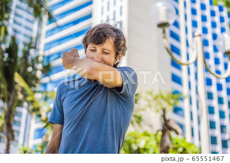 How to sneeze correctly. Man sneezes on the elbow. Concept of the spread of the virus 65551467