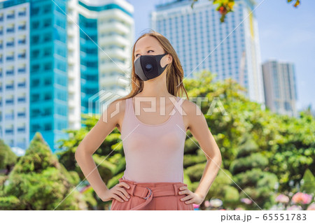 Fashionable black medical mask with filter in the city. Coronavirus 2019-ncov epidemic concept 65551783