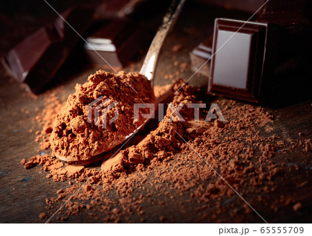 Broken  chocolate pieces and cocoa powder . 65555709