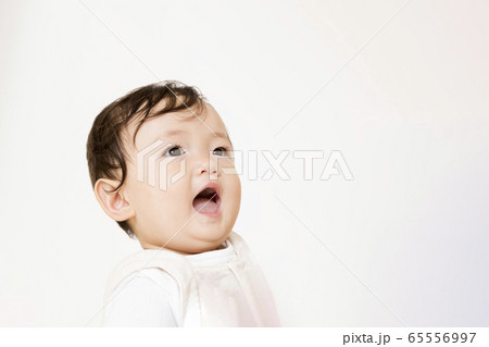 笑顔で見つめる赤ちゃんの顔アップの写真素材