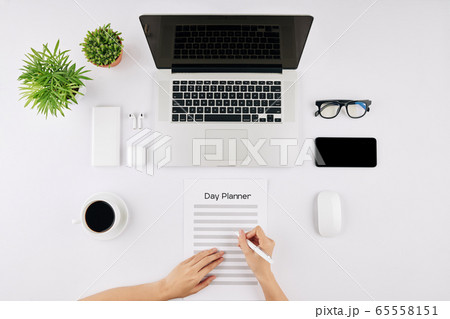 Businesswoman filling day planner Businesswoman filling day planner 65558151