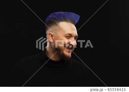 Man with blue or teal hair over dark background 65558423