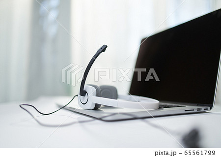 Laptop with black screen, headphones, microphone on table 65561799