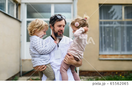 Children greeting father doctor in front of hospital, end of coronavirus. Children greeting father doctor in front of hospital, end of coronavirus. 65562065