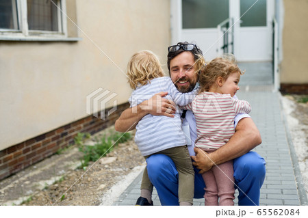 Children greeting father doctor in front of hospital, end of coronavirus. Children greeting father doctor in front of hospital, end of coronavirus. 65562084