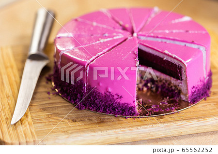 Pink and violet birthday cake without one piece. Dessert, holidays and delicious concept. 65562252