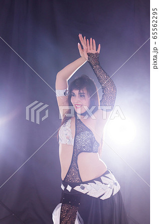 Portrait of a woman in oriental costume performing belly dance. Tribal fusion dance concept. Portrait of a woman in oriental costume performing belly dance. Tribal fusion dance concept. 65562295