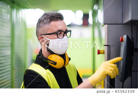 Man worker with protective mask working in industrial factory or warehouse. Man worker with protective mask working in industrial factory or warehouse. 65562339