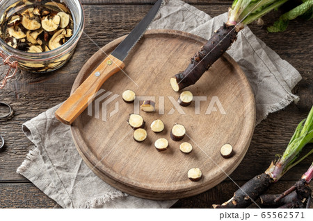 Cutting up fresh comfrey root to prepare tincture Cutting up fresh comfrey root to prepare tincture 65562571