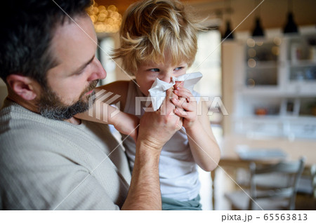 Father blowing nose of small sick son indoors at home. 65563813