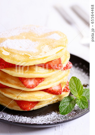 Pancakes with fresh strawberries and maple syrup Pancakes with fresh strawberries and maple syrup 65564468