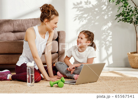 Cheerful woman with daughter using laptop during Cheerful woman with daughter using laptop during 65567541