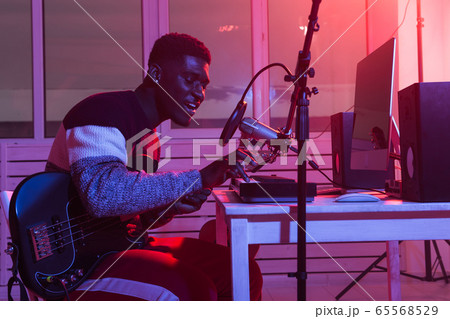 African american professional musician recording synthesizer in digital studio at home, music production technology concept. African american professional musician recording synthesizer in digital studio at home, music production technology concept. 65568529