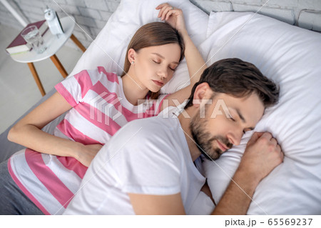 Pregnant young woman and her husband sleeping 65569237