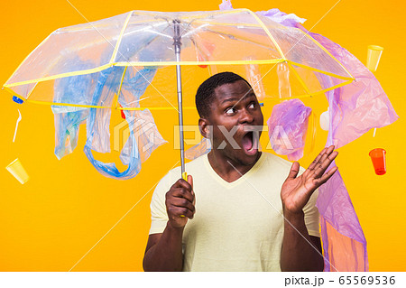 World Environment Day, plastic recycling problem and environmental disaster concept - Terrified man on yellow background with trash 65569536