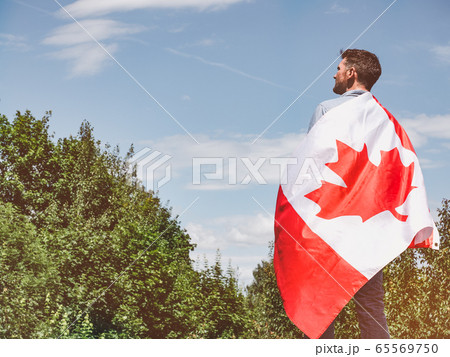 Attractive man holding Canadian Flag. National Attractive man holding Canadian Flag. National 65569750
