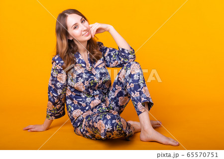 Excited young woman in home wear, widely smiling having fun. Isolated on yellow background. 65570751