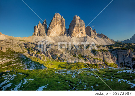 Tre Cime di Lavaredo Mountains with green grass, 65572987