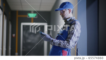 Janitor using a smartphone 65574860
