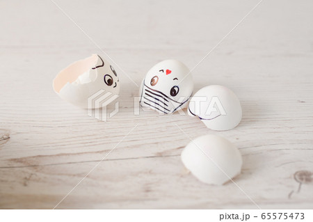 Broken white egg shells with painted faces 65575473