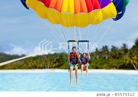 Kids parasailing. Water sport on summer vacation. 65575512