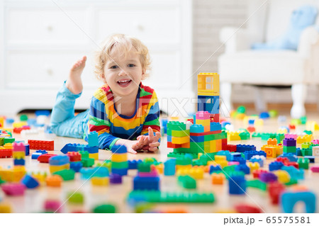 Child playing with toy blocks. Toys for kids. 65575581