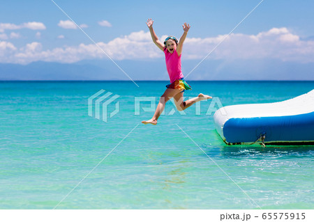 Kids on trampoline on tropical sea beach. Kids on trampoline on tropical sea beach. 65575915
