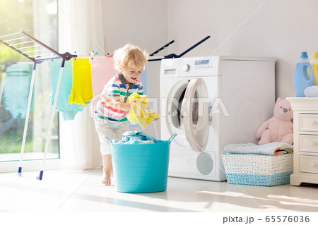 Child in laundry room with washing machine 65576036