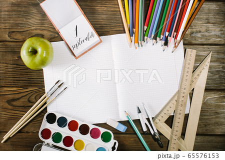 School supplies top corner border on a wooden desk background. first september 65576153