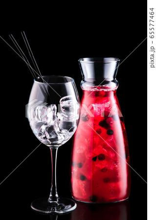 Jar with sangria with forrest berries and a wine glass isolated on black background Jar with sangria with forrest berries and a wine glass isolated on black background 65577464