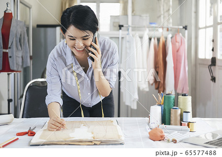 Young tailor design owner woman talking with Young tailor design owner woman talking with 65577488