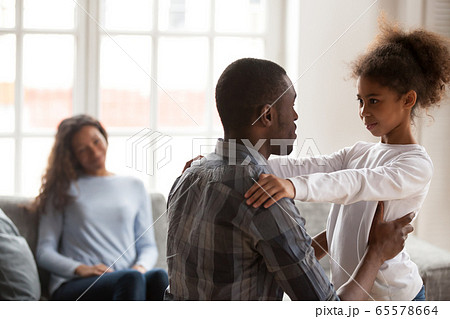 African dad talking to daughter having friendly conversation at 65578664