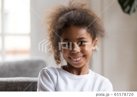 Cute funny little african american girl looking at camera Cute funny little african american girl looking at camera 65578720