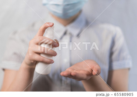 Close-up, teenage girl holding a spray bottle with an antiseptic, disinfection and sanitization, disinfection with bactericidal compound viruses, stay home, disease prevention disease protection. 65580905
