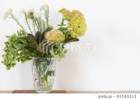 ガラスの花瓶に入ったトルコキキョウクリスマスローズライスフラワーの花束 左寄り ガラスの花瓶に入ったトルコキキョウクリスマスローズライスフラワーの花束 左寄り 65583213