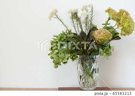 ガラスの花瓶に入ったトルコキキョウクリスマスローズライスフラワーの花束 右寄りの写真素材