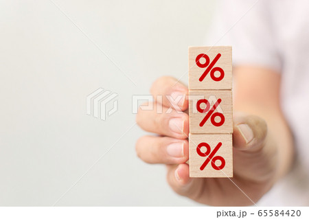 Hand holding wooden cube block increasing on top with icon percentage symbol upward direction Hand holding wooden cube block increasing on top with icon percentage symbol upward direction 65584420