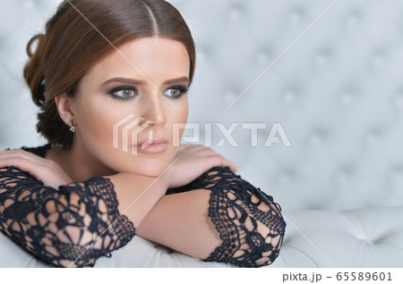 Portrait of beautiful young woman in bedroom Portrait of beautiful young woman in bedroom 65589601