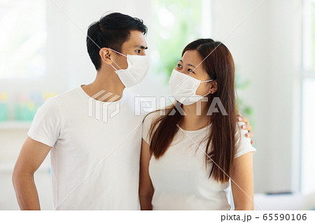 Young Asian couple in face mask in virus outbreak 65590106